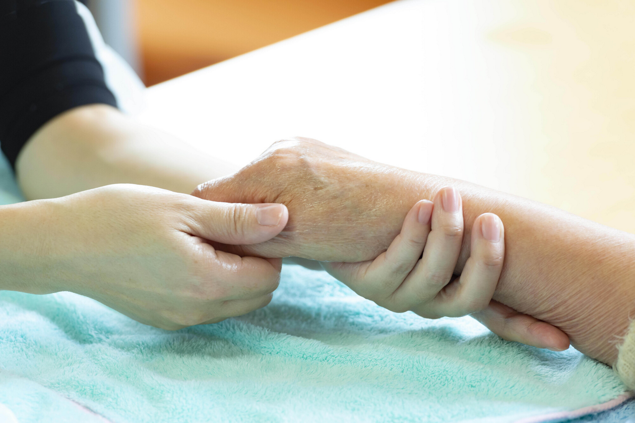 アロマセラピーの医療現場における活用。手を精油でマッサージするイメージ画像
