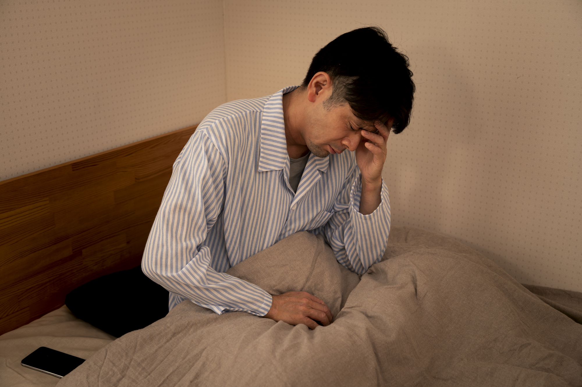自律神経失調症 症状チェック。自律神経失調症に悩む男性のイメージ写真