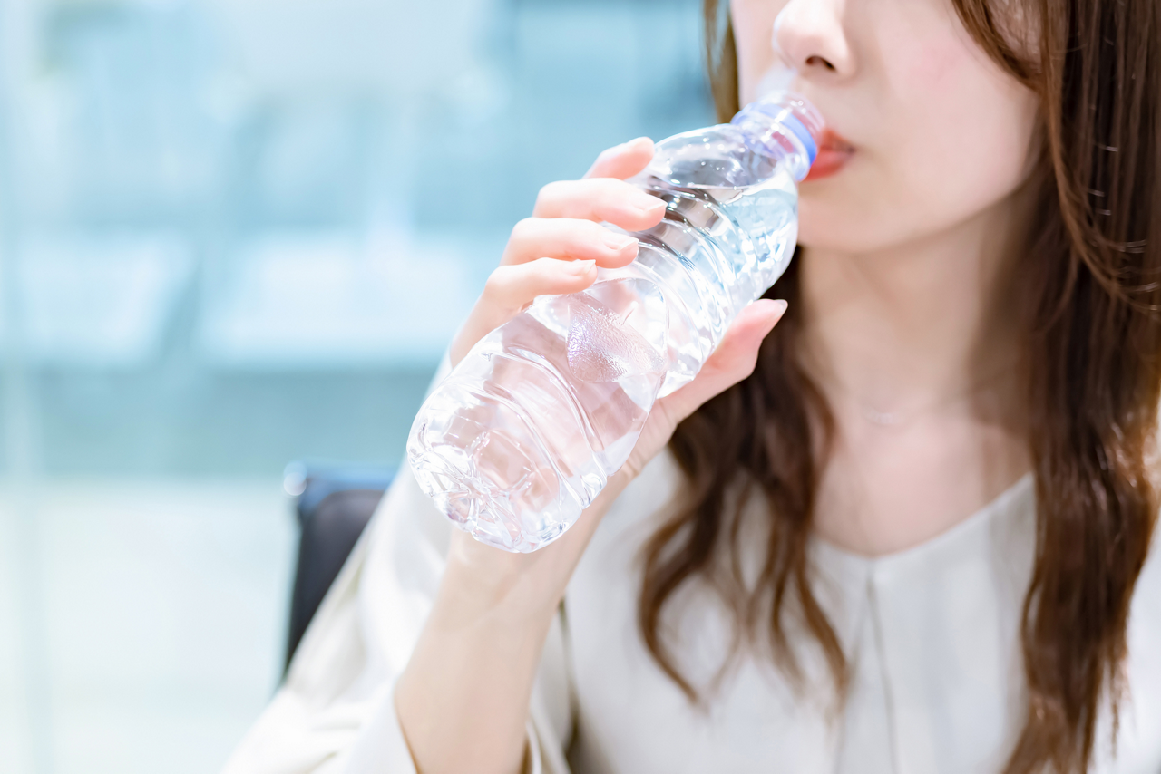 熱中症対策で、水を1日1.5Lを目安に8回に分けて摂取する練習をする女性のイメージ画像
