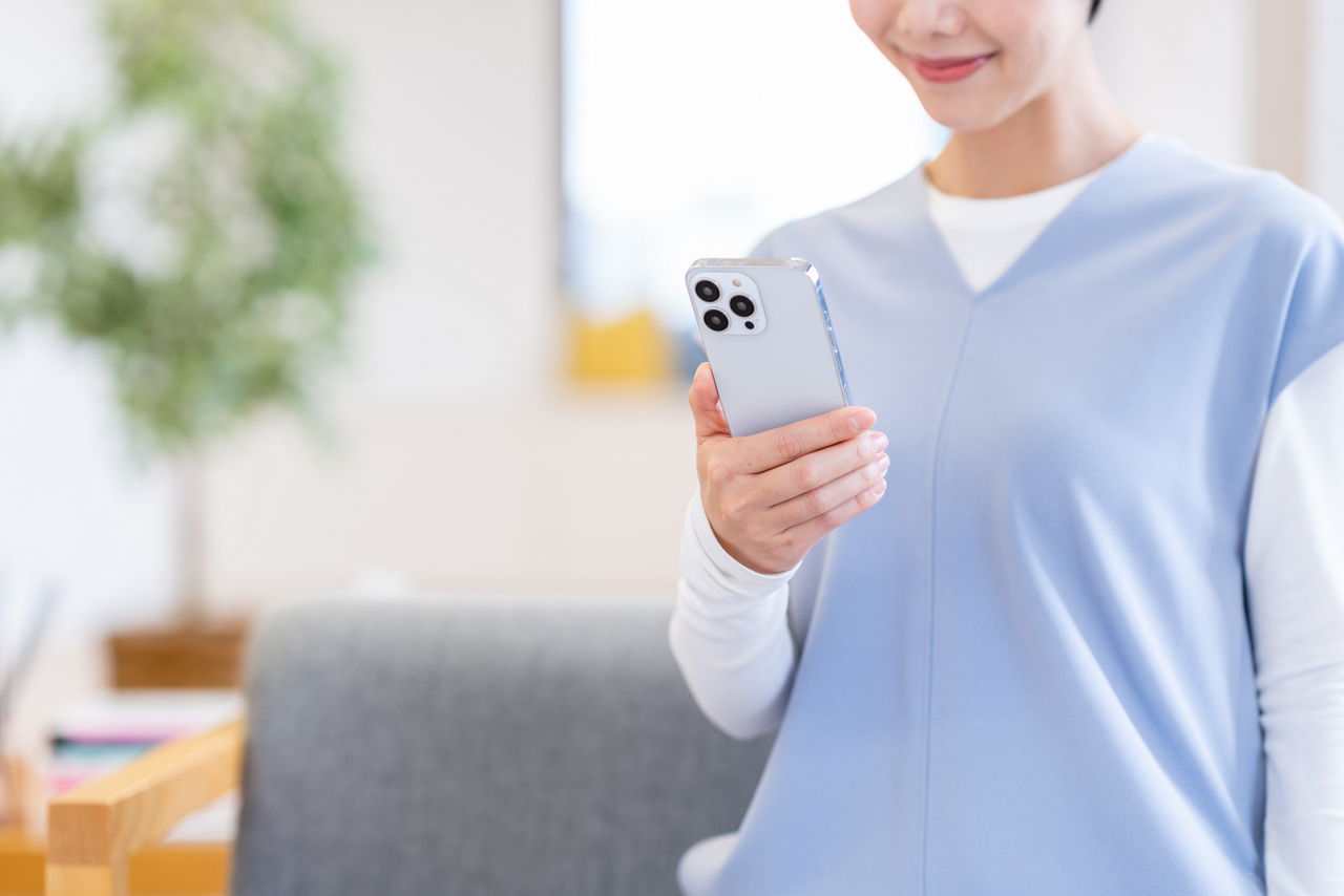 メノポハンドの原因となりうる動作である、片手でスマートフォンを使うイメージ画像