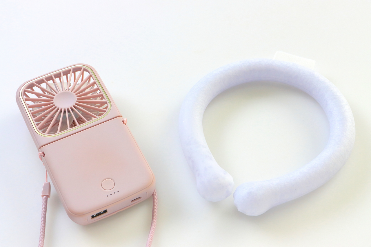 携帯扇風機やネッククーラーなどの冷却グッズも活用して、体の熱を逃がすイメージ画像