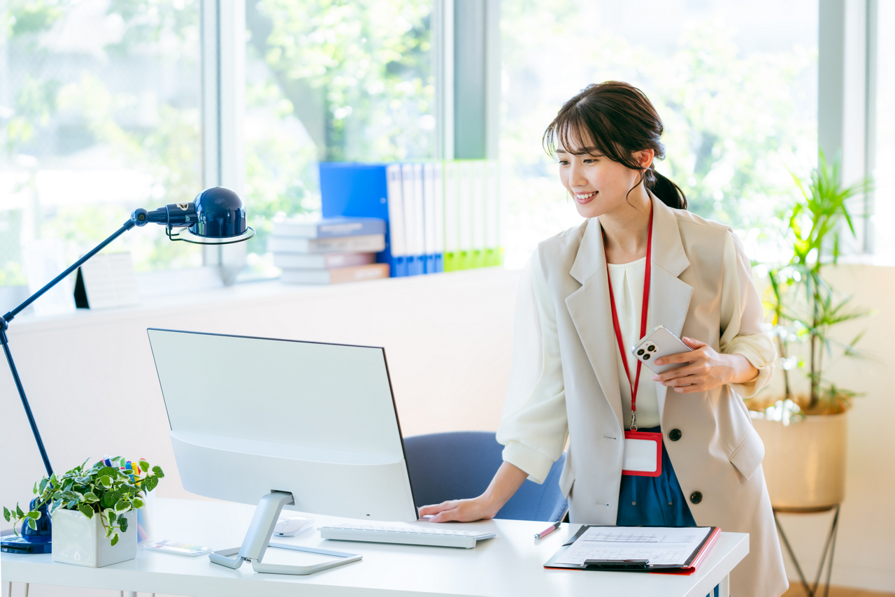 座りっぱなしを避けるため立ち上がる女性のイメージ画像