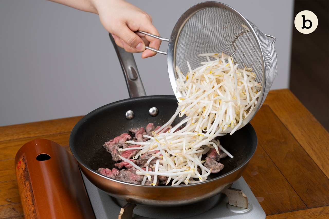 フライパンにサラダ油を中火で熱し、牛肉を炒める。８割ほど色が変わったら、もやしを加え、強めの中火で１分半ほど炒める。
