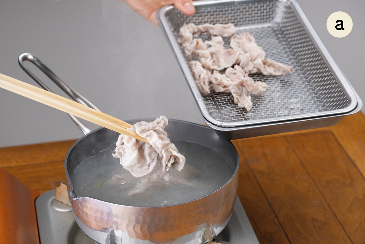 湯に酒を入れて再度沸騰させ、弱火にして豚肉の半量を茹でる。色が変わったらザルに広げ、そのまま冷ます。