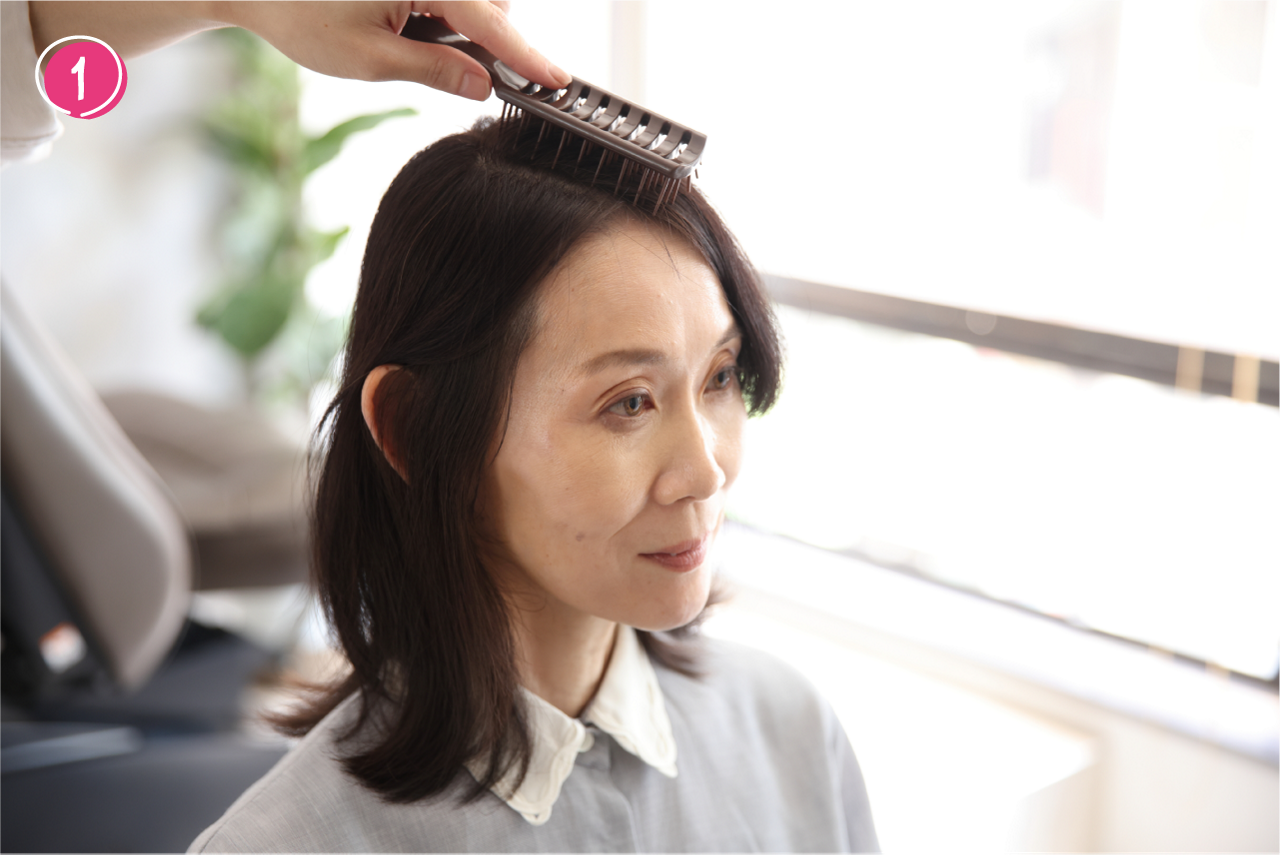 ➀ボリュームを出したい側に、分け目に沿ってヘアブラシを置く。