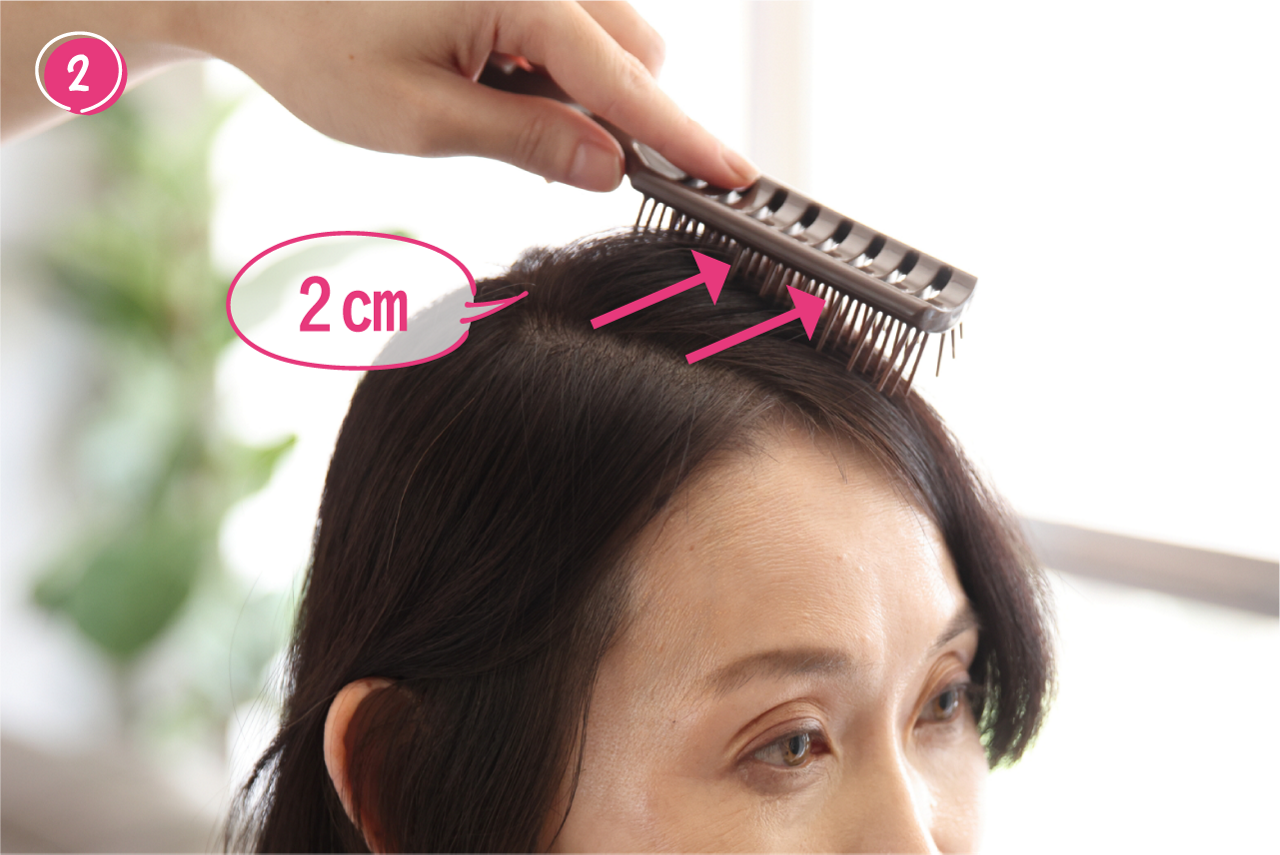 ②髪をとかすように、ヘアブラシを２cm滑らせる。