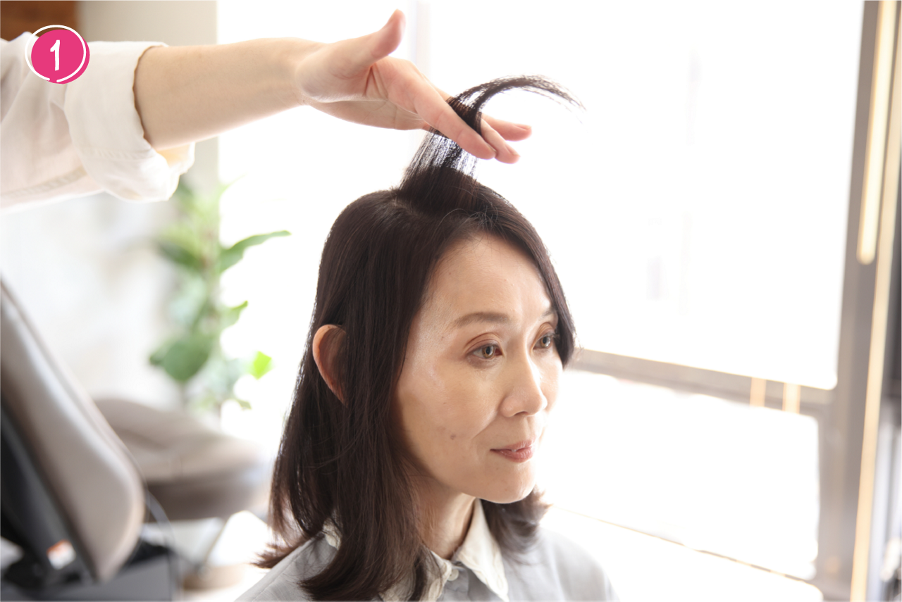➀分け目を中心に、左右１cmずつの髪を分け取る。