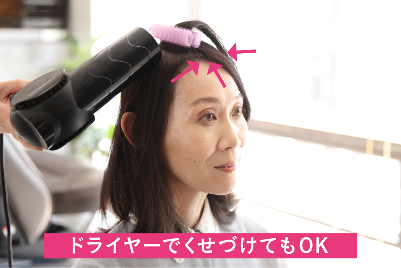 【急いでいる時はドライヤーで】分け目の両サイドと正面の3方向から、各3秒ずつドライヤーの熱を当て、熱が冷めたらクリップカーラーを外す（冷風にして冷ましてもよい）。