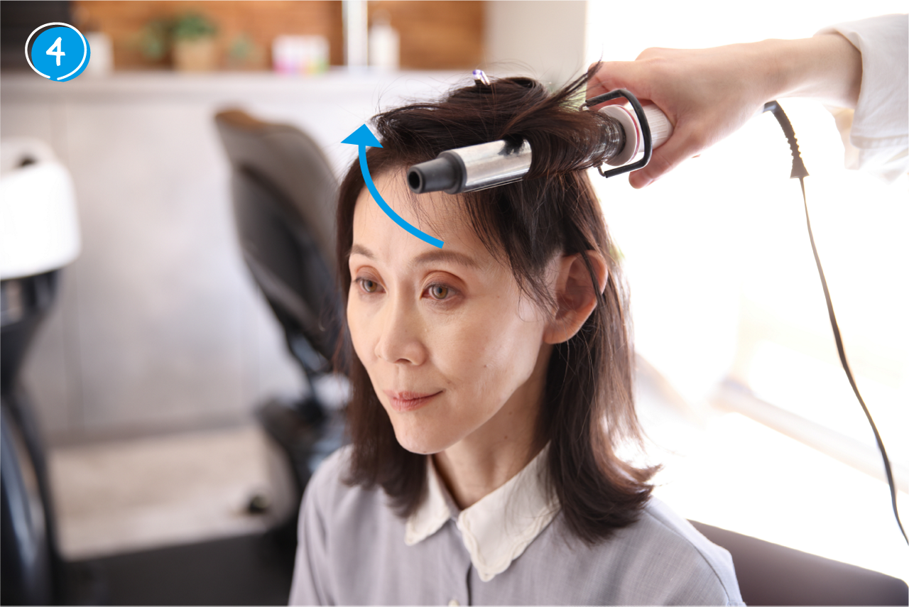 ➃下の髪が巻けたら、ヘアアイロンを内側へ回しながら、上の髪も内巻きに巻く。この時も床とヘアアイロンが平行になるように巻く。
