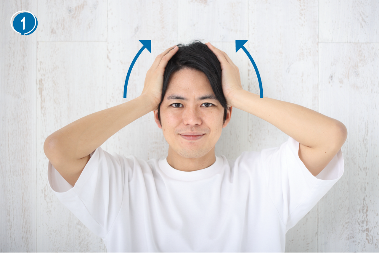頭皮マッサージ➀広げた両手のひら全体でこめかみをしっかり挟み、頭頂部に向けてゆっくり上げます。