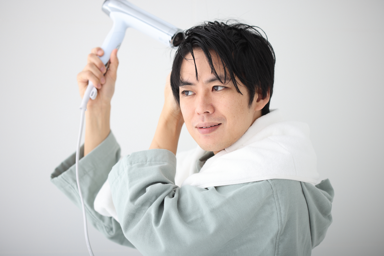 ドライヤーをかける男性のイメージ画像